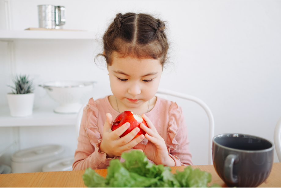 niña comiendo una manzana